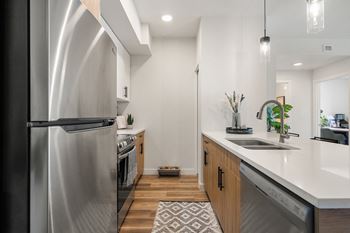 a renovated kitchen with stainless steel appliances and white counter tops